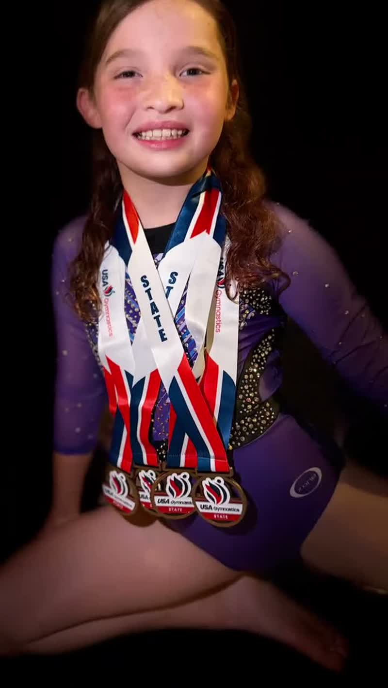 Evie Grace smiling with her State medals on
